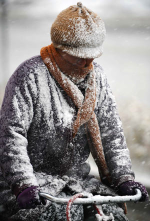 A bicyclist rides in snow in Yinchuan, capital of northwest China's Ningxia Hui Autonomous Region, Nov. 10, 2009. Most parts in north and northwest China witnessed a snowfall on Tuesday.[Xinhua]