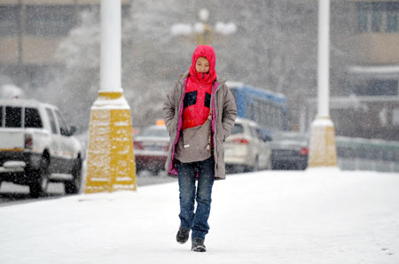 A pedestrian walks in snow on a street in Urumqi, capital of northwest China's Xinjiang Uygur Autonomous Region, Nov. 10, 2009. Most parts in north and northwest China witnessed a snowfall on Tuesday. [Xinhua]