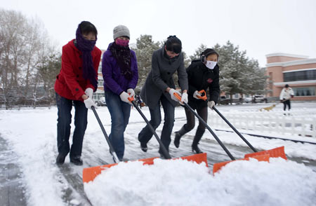 People clean up snow on a road in Fuyun County, northwest China's Xinjiang Uygur Autonomous Region, Nov. 10, 2009. Most parts in north and northwest China witnessed a snowfall on Tuesday. [Xinhua]