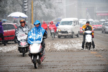 Residents ride in snow on a street in Taiyuan, capital of north China's Shanxi Province, Nov. 10, 2009. Most parts in north and northwest China witnessed a snowfall on Tuesday. [Xinhua]