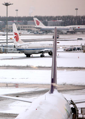 Planes are seen on the parking apron at Capital International Airport in Beijing, capital of China, Nov. 10, 2009. Some flights were suspended due to the second snowfall this winter hitting Beijing early Nov. 10. [Xinhua]