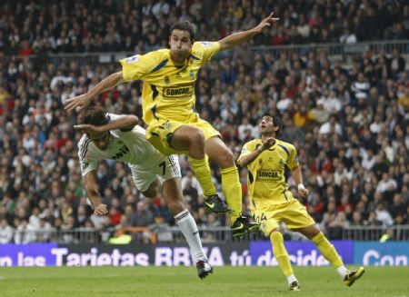 Real Madrid's Raul Gonzalez (L) and Alcorcon's Inigo Lopez fight for the ball during their King's Cup soccer match at Santiago Bernabeu stadium in Madrid November 10, 2009.[Xinhua/Reuters] 