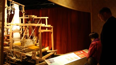 Visitors view a silk spinning machine during the media preview of the 'Travelling the Silk Road' exhibition at the American Museum of Natural History in New York Nov. 10, 2009. [Xinhua]