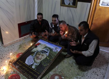 Fatah officials take part in a candle-lighting ceremony to mark the 5th anniversary of late Palestinian leader Yasser Arafat' death in an office in southern Gaza Strip town of Rafah on Nov. 10, 2009, a move to defy Hamas's ban on marking the death anniversary of Arafat in Gaza Strip. The event used to be a mass gathering in the Palestinian territories, but Hamas, which seized control of Gaza in 2007, has banned public activities on this occasion for two years. [Xinhua]