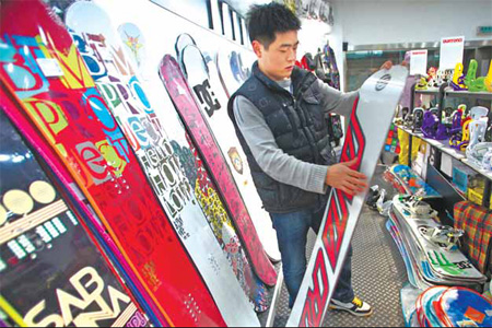 Zhang Jianshun, 23, selects a snowboard at a winter sports store yesterday.