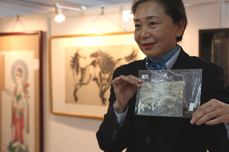 A staff member of Huachen Auctions, introduces a collection during the preview of 2009 Huachen Autumn Auction in Beijing, capital of China, on Nov. 10, 2009.[Xue Dongmei/Xinhua] 