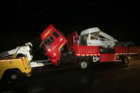 A truck and a minibus are trailered after a collision on a highway in Shanghai on November 9, 2009. [CFP]