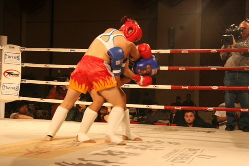 Xu Aihui (in red) from China fights with Sonrex Patanao from the Philippines during Muay Thai event - Battlefield XI &apos;Supremacy&apos; at China World Hotel in Beijing on Wednesday evening, November 11, 2009. China&apos;s first and only professional female Muay Thai star Xu Aihui defeated Sonrex Patanao in Wednesday&apos;s bout. [CRI]