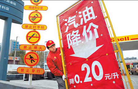 A worker at a foreign-funded gas station on the East Fourth Ring Road sets up a sales promotion board yesterday.[China Daily]