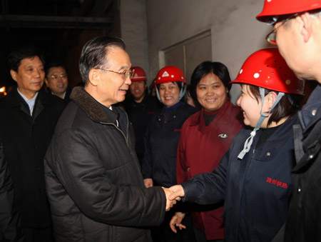 Chinese Premier Wen Jiabao (L, front) shakes hands with a worker during his inspection in Xijiao Heating Co. Ltd. in Shijiazhuang, capital of north China&apos;s Hebei Province, Nov. 12, 2009. [Liu Weibing/Xinhua]