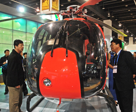 Visitors look at a French helicopter during the 2009 China International Tourism Commodities Fair in Yiwu city of east China&apos;s Zhejiang Province, Nov. 12, 2009. Some 60,000 exhibitors attended the fair which runs from Nov. 12 to 15. [Tan Jin/Xinhua]