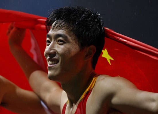 Chinese hurdler Liu Xiang holds the national flag after winning the men&apos;s 110m hurdles final at the 18th Asian athletics championships in Guangzhou on Thursday, November 12, 2009. [Xinhua]