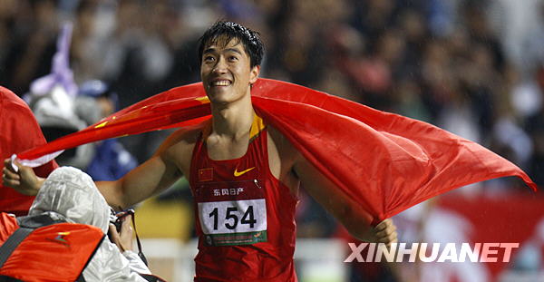 Chinese hurdler Liu Xiang holds the national flag after winning the men&apos;s 110m hurdles final at the 18th Asian athletics championships in Guangzhou on Thursday, November 12, 2009. [Xinhua]