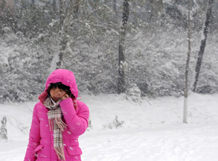 A woman walks in snow on a snow-covered road in Shenyang, capital of northeast China&apos;s Liaoning Province, on Nov. 13, 2009. The heaviest snowfall this winter hit Liaoning Province since the afternoon of Nov. 12. [Xinhua]