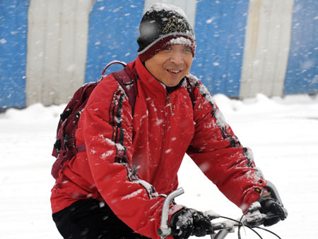 A man rides bicycle in snow on a snow-covered road in Shenyang, capital of northeast China&apos;s Liaoning Province, on Nov. 13, 2009. The heaviest snowfall this winter hit Liaoning Province since the afternoon of Nov. 12.[Xinhua]