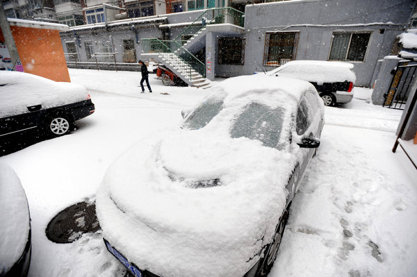 Vehicles are covered by heavy snow ni Shenyang, capital of northeast China&apos;s Liaoning Province, on Nov. 13, 2009. The heaviest snowfall this winter hit Liaoning Province since the afternoon of Nov. 12. [Xinhua]