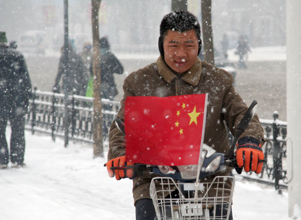 A man rides bicycle in snow on a snow-covered road in Shenyang, capital of northeast China&apos;s Liaoning Province, on Nov. 13, 2009. The heaviest snowfall this winter hit Liaoning Province since the afternoon of Nov. 12.[Xinhua] 