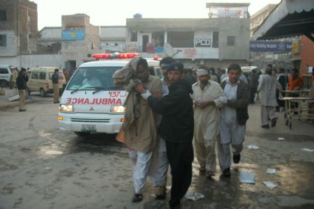 People carry a man injured in a blast in Peshawar, Pakistan, Nov. 13, 2009. A bomber on Friday exploded his explosive-packed car near the office of spy agency ISI (Inter-Services Intelligence) in Peshawar, capital of North West Frontier Province, leaving at least 8 people dead and over 30 others injured. [Xinhua]