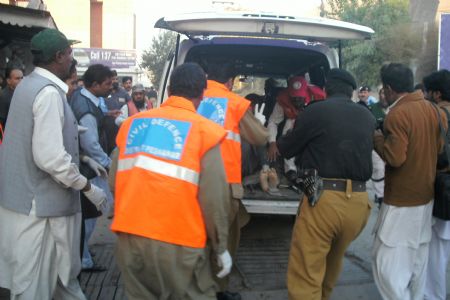 People carry a man injured in a blast in Peshawar, Pakistan, Nov. 13, 2009. [Xinhua]