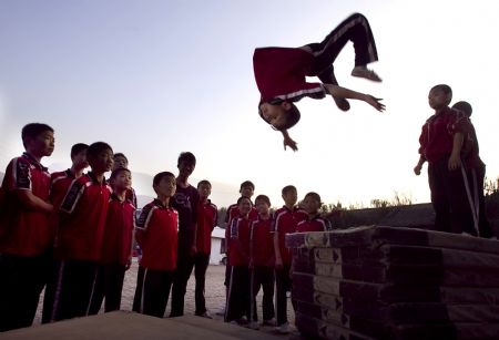  He Minxian, a 9-year-old kid, practises somersault in the Shaolin Tagou Kung Fu (Martial Art) Institute at the foot of Mountain Song in Dengfeng, a city of central China&apos;s Henan Province, Oct. 12, 2009.[Wang Song/Xinhua]