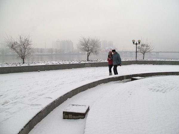 People walk in snow on a snow-covered road in northeast China's Jilin Province, on Nov. 13, 2009. [CFP]