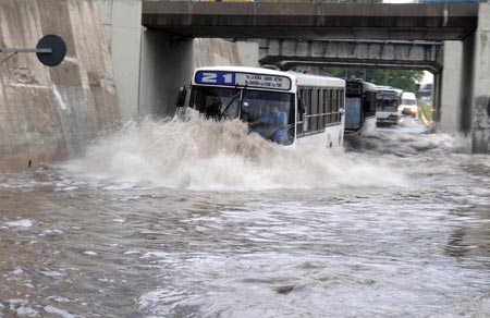 A bus runs slowly on a flooded road in Buenos Aires, capital of Argentina, on Nov. 14, 2009. Roads were flooded after a heavy rain hit Buenos Aires on Friday. [Telam/Xinhua]