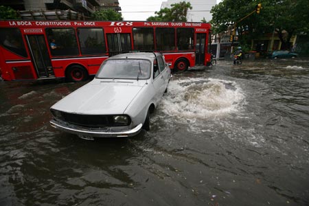 Vehicles run slowly on a flooded road in Buenos Aires, capital of Argentina, on Nov. 14, 2009. [Niceto Vega/Xinhua]