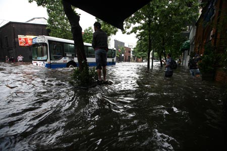 A bus runs slowly on a flooded road in Buenos Aires, capital of Argentina, on Nov. 14, 2009. [Niceto Vega/Xinhua]