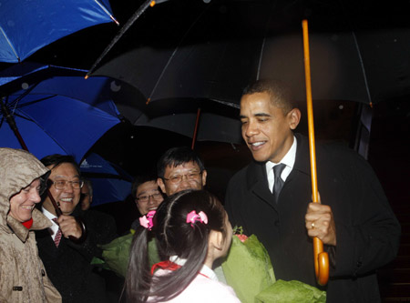 A girl presents a bouquet to U.S. President Barack Obama after he arrives at Shanghai Pudong International Airport on Nov. 15, 2009. [Xinhua]