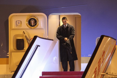 US President Barack Obama is ready to step out Air Force One as he arrives at Pudong International Airport in Shanghai November 15, 2009. [China Daily]