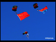 A flag of the PLA flows during a bailout performance of an air force show in Beijing, November 15, 2009.[Xinhua]