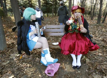 Schoolgirls in costumes take a break on a bench during the monthly Seoul Comic World event in Seoul November 15, 2009.[Xinhua/Reuters]