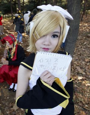 A schoolgirl holds a note which reads, 'Please, take my pictures' during the monthly Seoul Comic World event in Seoul November 15, 2009.[Xinhua/Reuters]