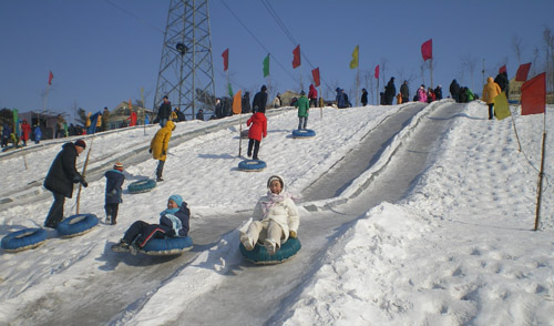 Adults and kids share the fun of sledging. [David Ferguson/China.org.cn] 大人小孩一起滑雪橇，其乐融融。 