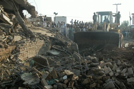 Local residents gather around the site of a suicide bomb attack on the outskirts of Peshawar, Nov. 16, 2009. A suicide car bomb ripped through a Pakistan police station in the northwest city of Peshawar on Monday, devastating part of the building and killing at least 6 people. [Xinhua]