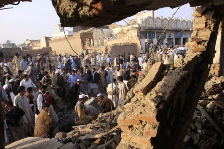 Local residents gather around the site of a suicide bomb attack on the outskirts of Peshawar, Nov. 16, 2009. [Xinhua]