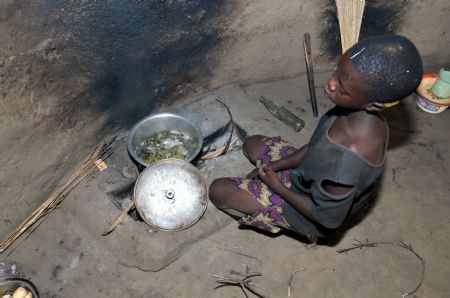 Innocent Apio helps to prepare for dinner at Ajulu village, in Gulu district, northern Uganda, on Oct. 20, 2009. [Tian Ye/Xinhua] 