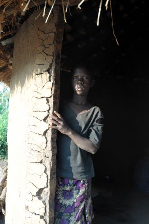 Innocent Apio stands at the door of the hut at Ajulu village, in Gulu district, northern Uganda, on Oct. 20, 2009. [Tian Ye/Xinhua]