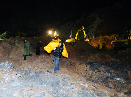 A rescuer carries the body of a landslide victim in Zhongyang County of Lvliang in North China's Shanxi province, November 16, 2009.[Xinhua] 