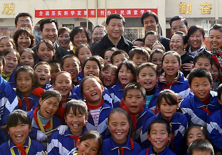 Chinese Vice President Xi Jinping poses for a group photo with pupils and teachers of Fuzhou Hope Primary School in Yan'an City, during his visit in northwest China's Shaanxi Province, Nov. 14, 2009.
