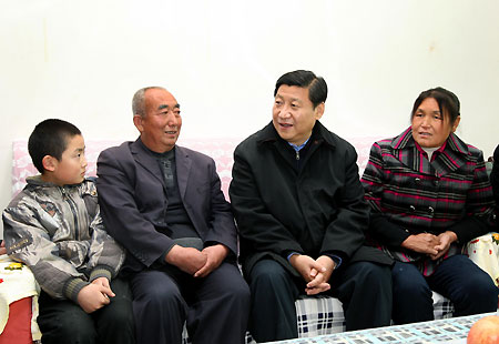 Chinese Vice President Xi Jinping (2nd R) talks with family members of local farmer Fan Mingliang (2nd L) in Ansai County, during his visit in northwest China's Shaanxi Province, Nov. 14, 2009. 