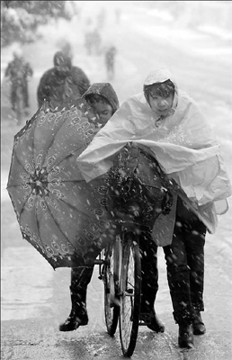 A resident in Hefei, capital of East China's Anhui province, sends her child to school in heavy snow yesterday. 