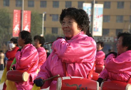 A group of retired women play waist drum, a popular musical instrument in norther region of China, together for joy at a street corner in downtown Xining, on Oct. 31, 2009. [Xinhua]