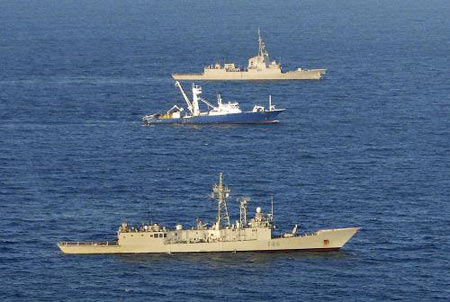 The Spanish tuna fishing boat Alakrana sails between two accompanying Spanish warships in the Indian ocean after it was freed from Somali pirates November 17, 2009. [Xinhua/Reuters]