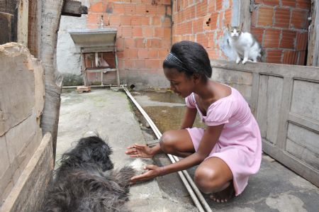 Photo taken on Oct. 5, 2009 shows Maria Luisa plays with a dog at home in Rio De Janeiro of Brazil.