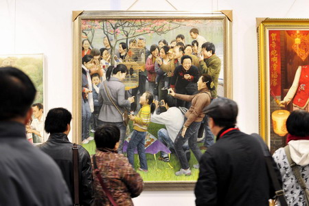  Visitors look at artworks displayed at the 12th annual West Lake Art Expo in Hangzhou, Zhejiang province, November 19, 2009.[Xinhua]