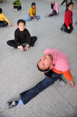 Deaf-mute student Han Liang (F) demonstrates dancing skills for her classmates during a dance class at a special education school in Yichang City, Central China&apos;s Hubei province, November 19, 2009. [Xinhua]