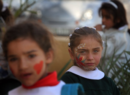 Palestinian children have their faces painted and gather to commemorate the Universal Children&apos;s Day, which falls on Friday, near their home, south of Gaza City, Nov. 19, 2009. [Xinhua]