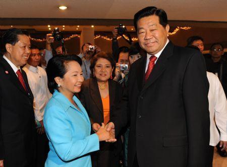 Jia Qinglin (R), chairman of the National Committee of the Chinese People&apos;s olitical Consultative Conference, shakes hands with Philippine President loria Macapagal Arroyo ahead of the opening of the 10th World Chinese Entrepreneurs Convention (WCEC) in Manila, capital of the Philippines, on Nov. 20, 2009. [Fan Rujun/Xinhua]