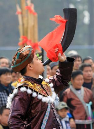 A man blows the horn to pray for good luck and bumper harvest during the Lusheng and Horse Fight Festival held in the Sports Park in Rongshui Miao Autonomous County, southwest China's Guangxi Zhuang Autonomous Region, Nov. 21, 2009.(Xinhua/Long Tao)